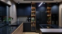 Nowoczesna ciemna kuchnia z blatem TechniStone Starlight Black i drewnianymi detalami.