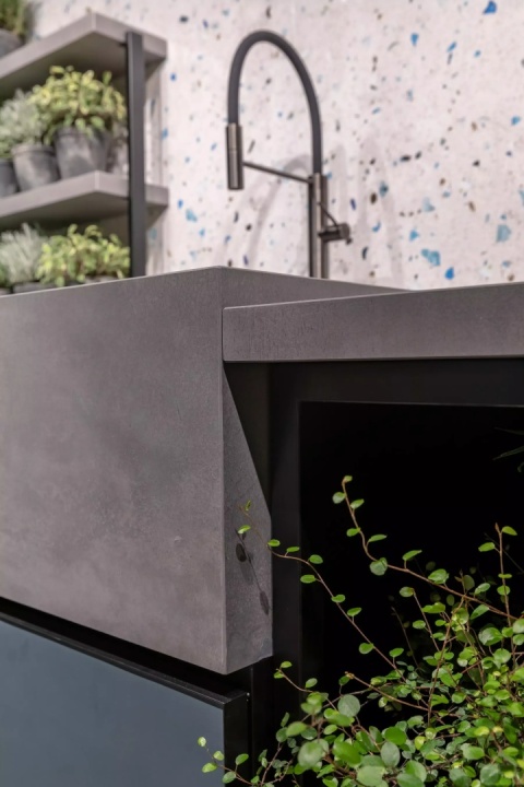 Wyspa kuchenna z FLORIM Stone Cement Dark Grey Matte Soft i czarną baterią.