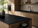 Kuchnia z FLORIM Stone Color Black Matte, czarnym spiekiem na blacie i wyspie kuchennej.