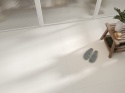 Jasna posadzka Neolith Nivola Matt w minimalistycznym wnętrzu z drewnianą ławką