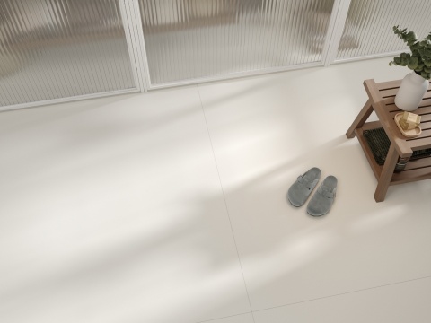 Jasna posadzka Neolith Nivola Matt w minimalistycznym wnętrzu z drewnianą ławką