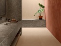 Łazienka z Neolith Toscano Riverwashed na umywalce i ścianie w połączeniu z ciepłą terakotą.