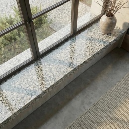 Parapet Crema FALCO przy dużym oknie w jasnym wnętrzu z naturalnymi beżowymi dodatkami
