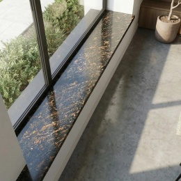 Parapet granitowy Gold Antracite FALCO 3 cm poler przy dużym oknie w nowoczesnym wnętrzu