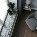 Granitowy parapet Grey FALCO w jasnym wnętrzu z drewnianą podłogą i szarym fotelem