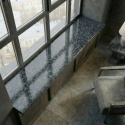 Polerowany parapet Steel Grey FALCO w nowoczesnym wnętrzu z dużymi przeszkleniami.