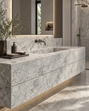Luksusowa łazienka ze spiekiem Blue Granite, kamienna umywalka i jasnoszare ściany o wyrazistym rysunku.
