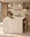 Ciepła kuchnia z wyspą wykończoną spiekiem FLORIM Stone Gold Travertine i drewnianą zabudową.