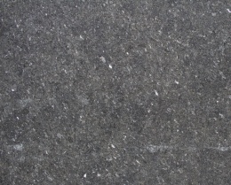 Zbliżenie granitu Black Pearl w wykończeniu waterjet z ciemnoszarą strukturą i jasnymi minerałami