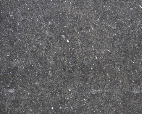 Zbliżenie granitu Black Pearl w wykończeniu waterjet z ciemnoszarą strukturą i jasnymi minerałami