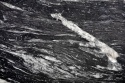 Cosmic Black szczotkowany 20 i 30 mm – czarny granit z falistymi białymi żyłami i strukturalną powierzchnią.