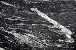 Cosmic Black szczotkowany 20 i 30 mm – czarny granit z falistymi białymi żyłami i strukturalną powierzchnią.