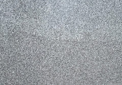 Granit Gris Messi fiammato – zbliżenie drobnoziarnistej powierzchni w chłodnych odcieniach szarości i bieli.