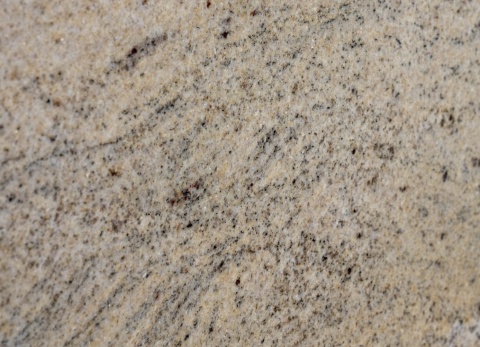 Ivory Gold Natural – jasny granit z drobnymi grafitowymi minerałami, beżowymi smugami i spokojnym, falistym rysunkiem.