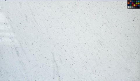 Duża płyta granitu Perfect White poler, białe tło z subtelnymi szarymi smugami i rozsianymi ciemnymi punktami
