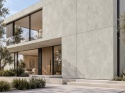 Laminam Oxide Perla 3 mm jako jasna okładzina elewacji nowoczesnego domu z dużymi przeszkleniami.