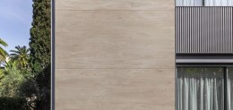 Elewacja pokryta okładziną ścienną wykonaną  ze spieku  Summer Dala o jasnej, miodowo-drewnianej kolorystyce .