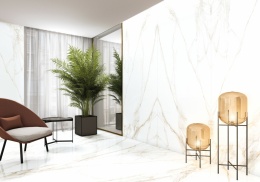 Ściana pokryta okładziną wykonaną ze spieku  Calacatta Extra Gold o czysto białym tle z dynamicznymi, złoto-szarymi żyłami.