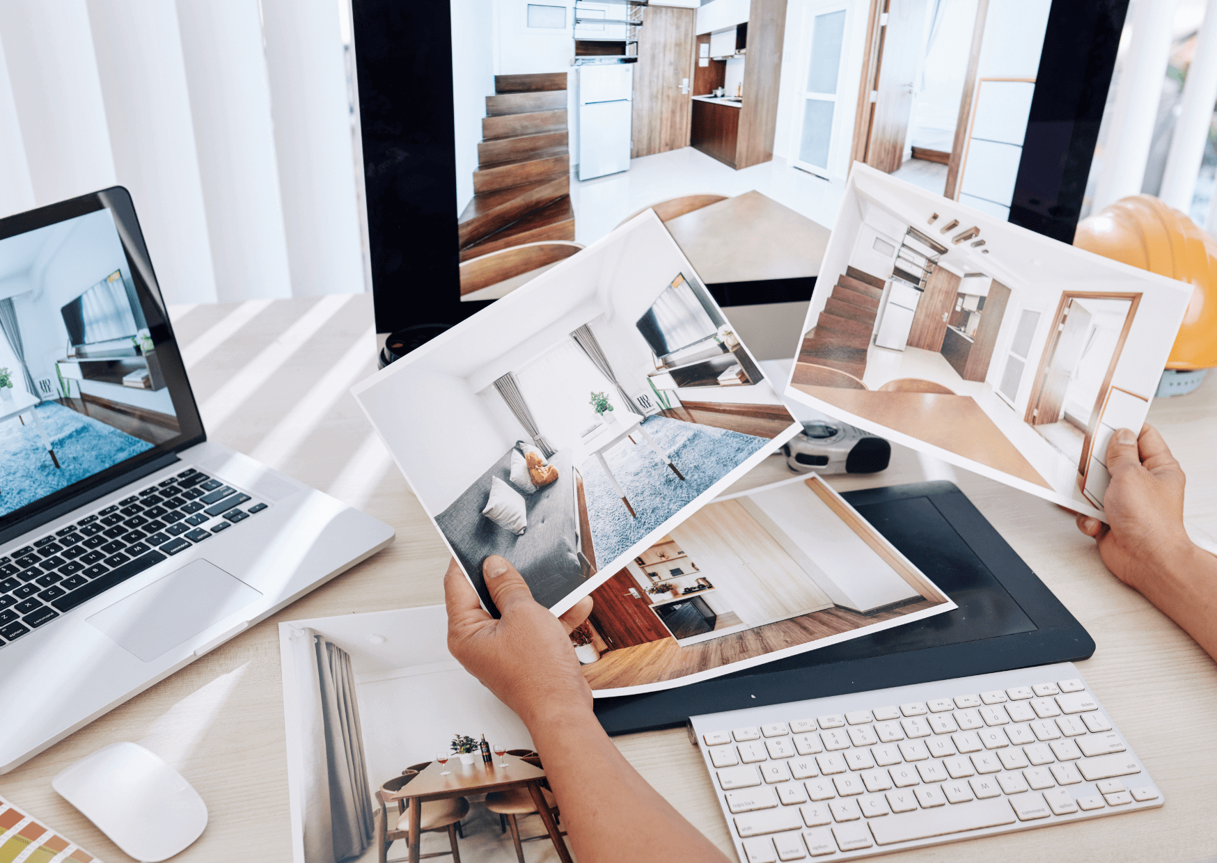 Architekt wnętrz analizujący wizualizacje i fotografie projektowe na biurku – planowanie realizacji z użyciem materiałów wykończeniowych