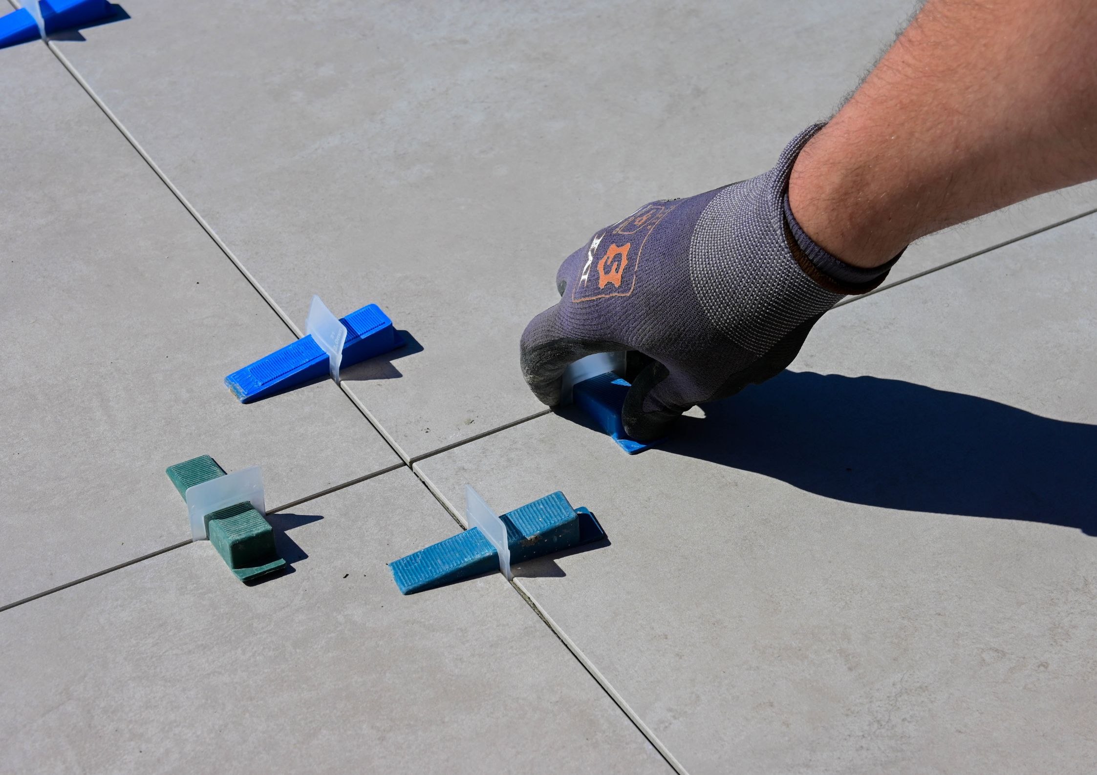 Ustawianie klipsów poziomujących między płytkami 